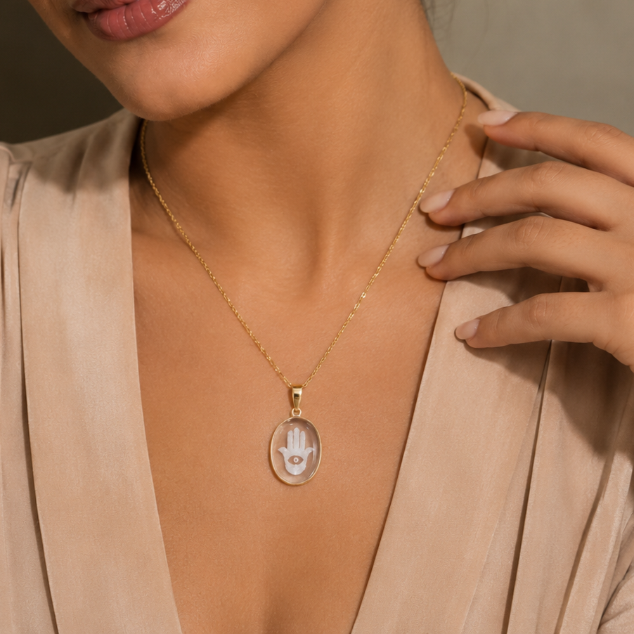 Model wearing rock crystal oval hamsa hand intaglio pendant on gold chain – clear quartz evil eye protection necklace