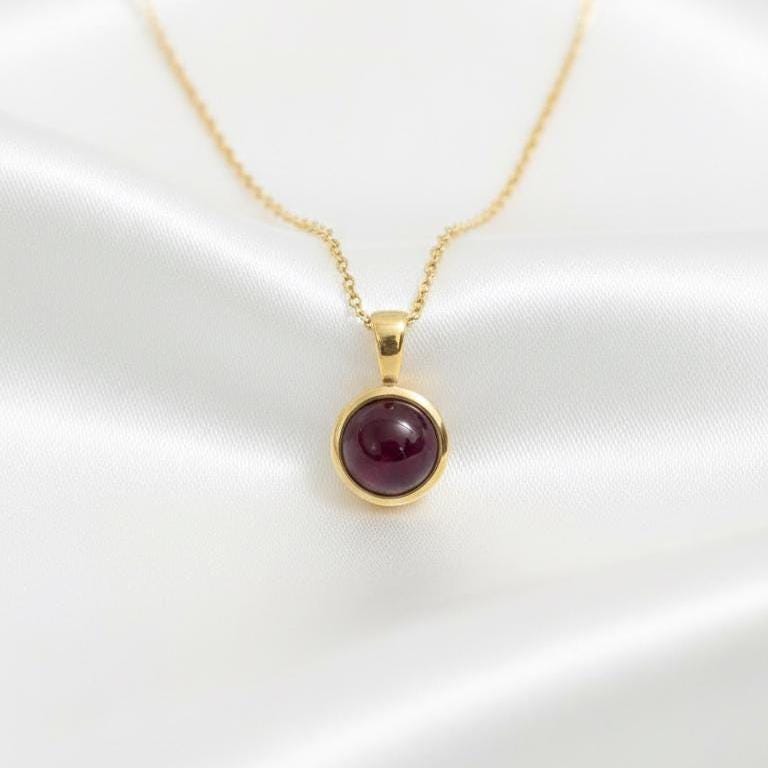 14K Gold Natural Ruby Pendant on White Satin – Round Ruby Cabochon Bezel Necklace Lifestyle Shot

