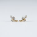 Pair of 14k solid yellow gold leaf branch stud earrings, each with three leaf shapes set with sparkling natural diamonds on a curved gold stem, shown on a soft white background.