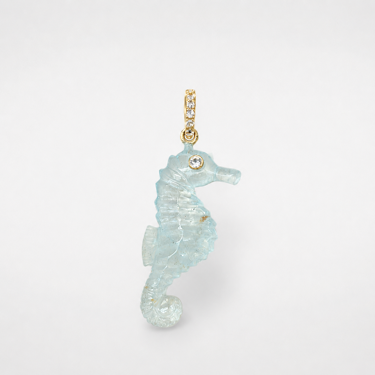 Hand-carved aquamarine seahorse pendant with 14k yellow gold pavé bail set with white topaz accents and bezel-set white topaz eye, translucent pale blue gemstone with natural inclusions
